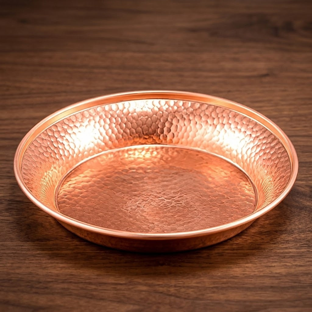 A hammered copper bowl with a polished rim, resting on a dark brown wooden surface.