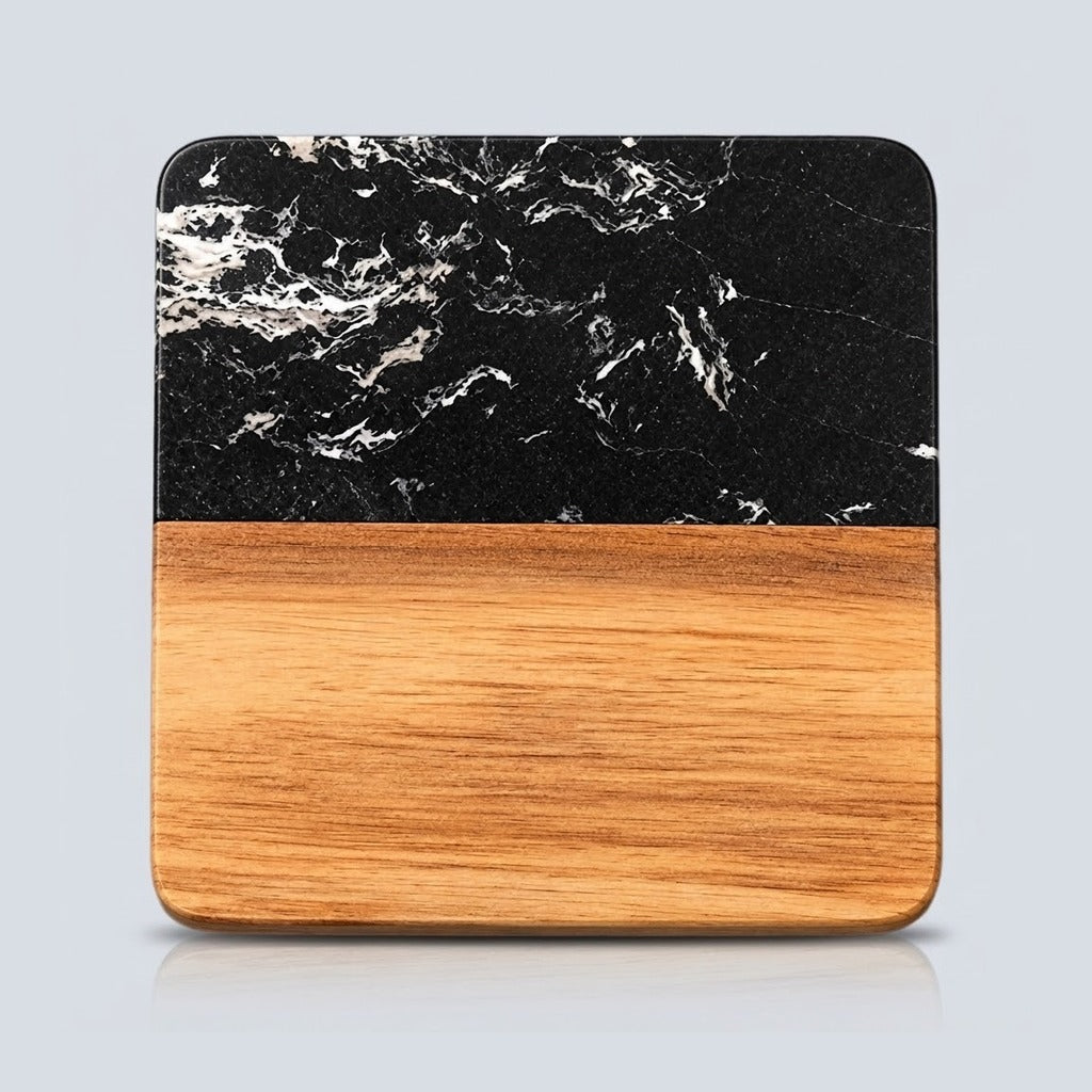 A square wooden serving board or tray with rounded corners, featuring a black marble top half with white veining and a natural light brown wood grain bottom half, shown on a light gray background.