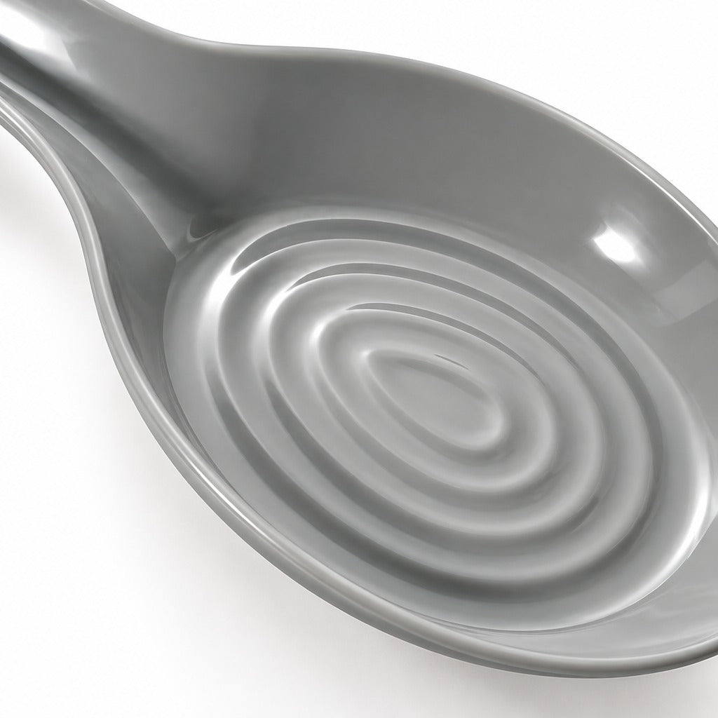 A close-up of a glossy gray ceramic spoon rest with concentric circular ridges inside the bowl, shown on a white background.