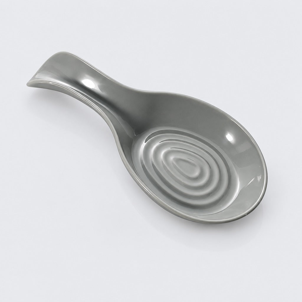 A gray ceramic spoon rest with a glossy finish and concentric ripple detailing in the bowl, shown on a clean white background.