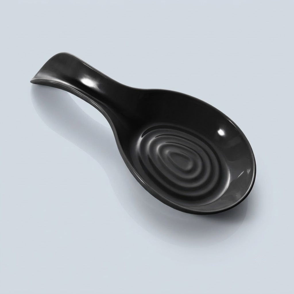 A glossy black ceramic spoon rest with a textured concentric ring design inside the bowl, shown on a light gray background.