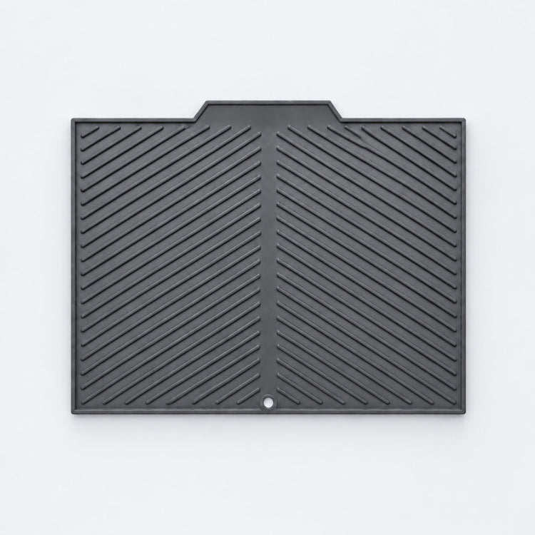 A black rubber or plastic protective cover with a textured diagonal ribbed pattern and a small circular hole near the bottom center, shown flat against a light gray background.