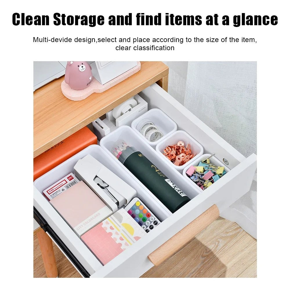 Organized drawer with compartments containing various items on a wooden desk.
