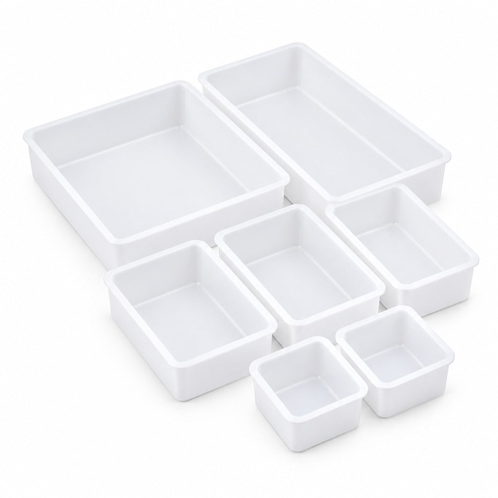 Set of seven white plastic rectangular storage bins in various sizes, arranged on a clean white background.