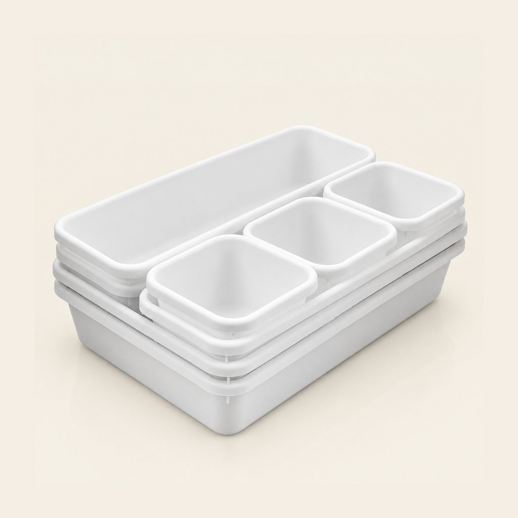 A stack of white plastic organizer bins with one large rectangular compartment and four smaller square compartments, shown on a light beige background.