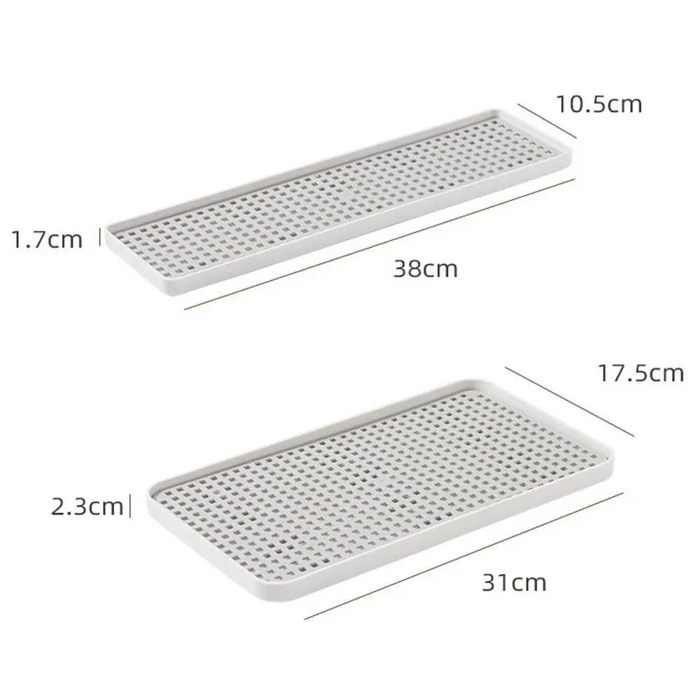 Two rectangular white perforated trays shown on a light gray background with dimension labels and measurements: one 38cm by 10.5cm by 1.