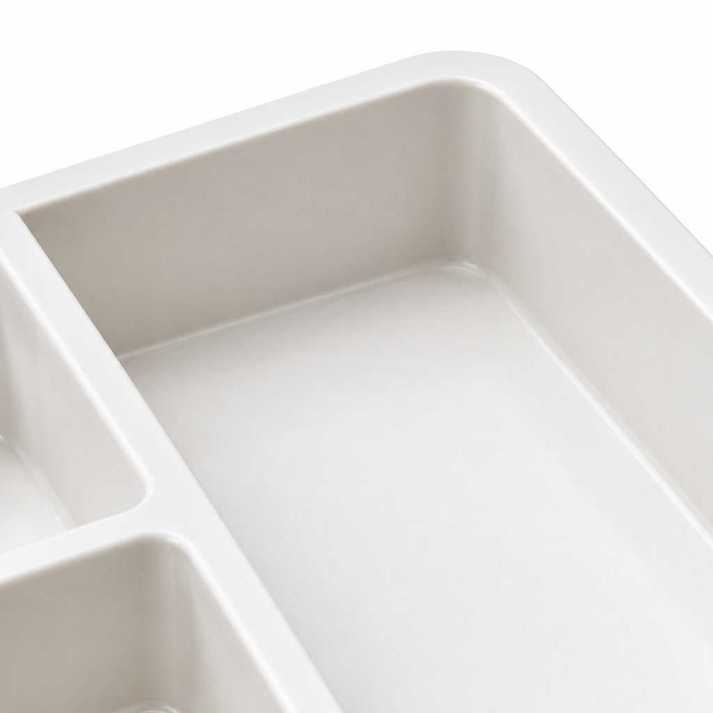 Close-up of a light gray divided tray with rectangular compartments, showing the smooth interior surfaces and clean edges against a white background.
