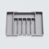 A gray plastic drawer organizer tray with five vertical divider slots and a larger compartment on the left, shown on a light gray background.