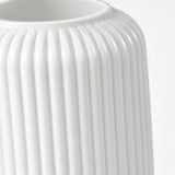 Close-up of a white ribbed ceramic vase with a flared rim, shown against a plain white background.