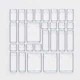 A set of clear plastic rectangular storage containers with a textured grid pattern, arranged in a neat grid on a light gray background.