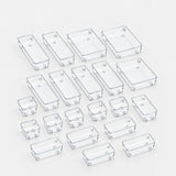 A set of clear plastic rectangular junction boxes in various sizes, arranged on a light gray background.