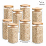 Set of eight clear glass canisters with square bamboo lids, filled with oats, shown on a white background with dimension markings indicating 34oz / 1000ml capacity.