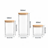 Three clear glass storage jars with light wood lids shown on a white background, labeled with capacities 540ml, 1004ml, and 450ml, with height and width measurements indicated.