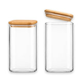 Two clear glass canisters with bamboo lids on a white background, one closed and one open to show the interior.