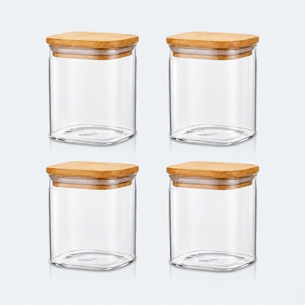 Four clear glass canisters with square bamboo wood lids, arranged in a 2x2 grid on a light gray background.