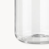 Close-up of a clear glass container or vase showing the lower curved edge and base against a white background.