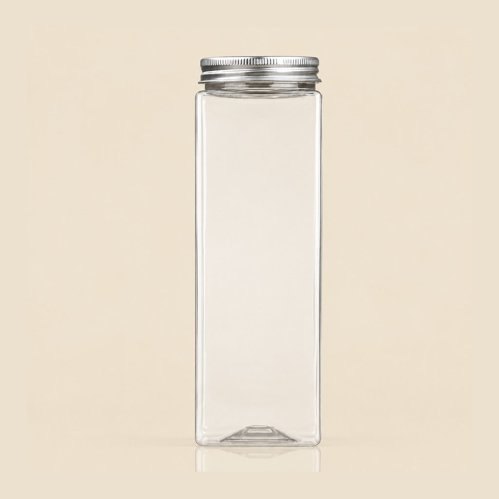 A clear rectangular glass bottle with a silver metal screw cap, centered on a solid beige background.