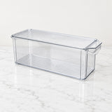 A clear plastic refrigerator storage bin with a ribbed lid and side handle, shown on a white marble surface against a white background.