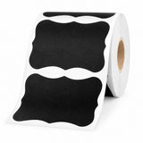 A roll of black decorative labels with a wavy, scalloped border design, shown on a clean white background.