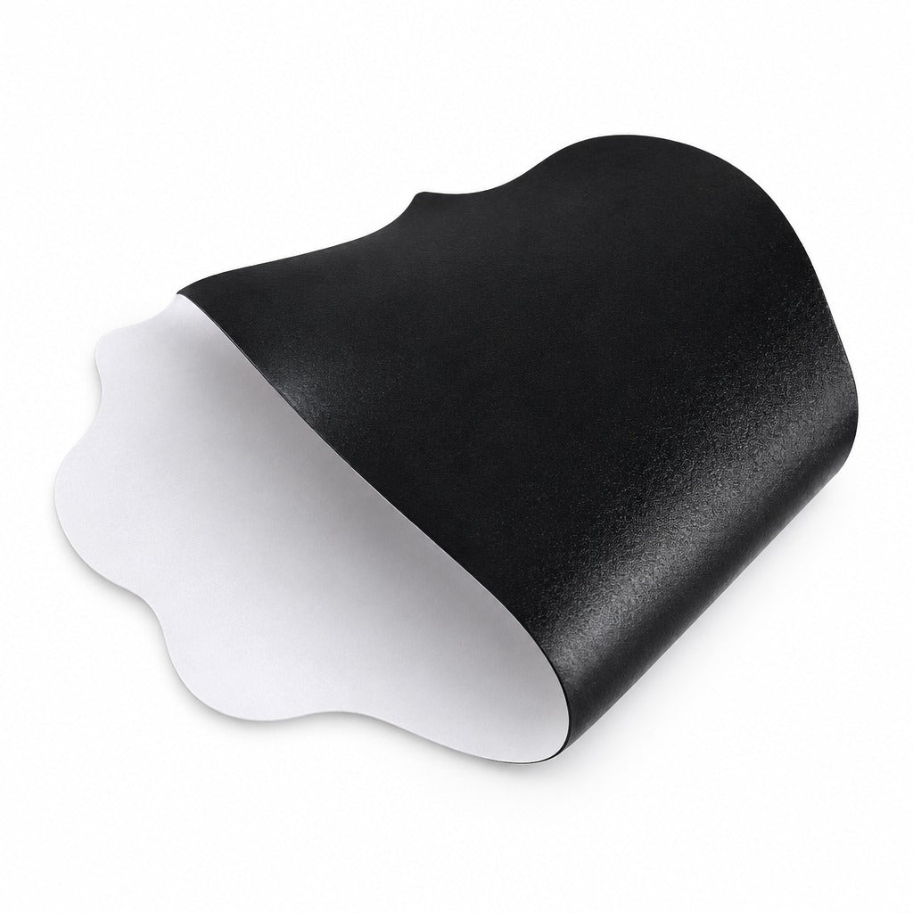 A black contoured mouse pad with a textured surface, shown partially unrolled to reveal a white adhesive backing, set against a plain white background.