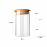 A clear glass jar with a light brown wooden lid, shown with dimension lines and labels indicating height and width measurements on a white background.