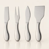 Four polished stainless steel cheese knives with curved handles, arranged in a row against a warm off-white background with soft reflections below.