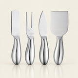 Four stainless steel cheese and charcuterie tools with ergonomic handles, arranged in a row against a warm off-white background.