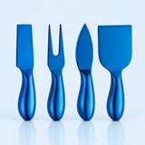 Four metallic blue cheese knives and spreaders with matching handles, arranged in a row on a light blue reflective surface.