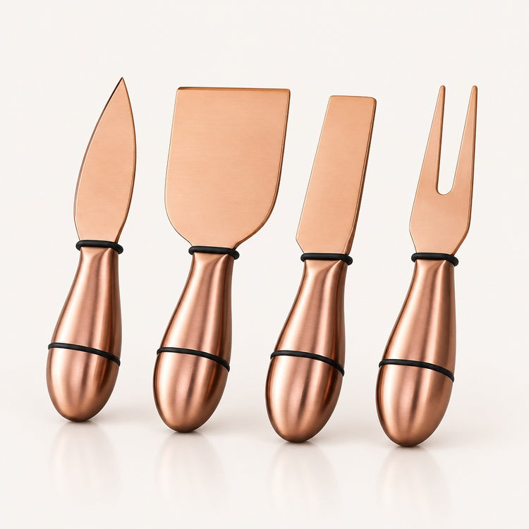 Four metallic copper-colored cheese and fruit utensils with black bands near the handles, arranged upright on a clean white background.