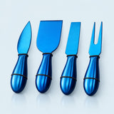 Four metallic blue cheese knives with matching handles, arranged in a row on a light gray reflective surface.