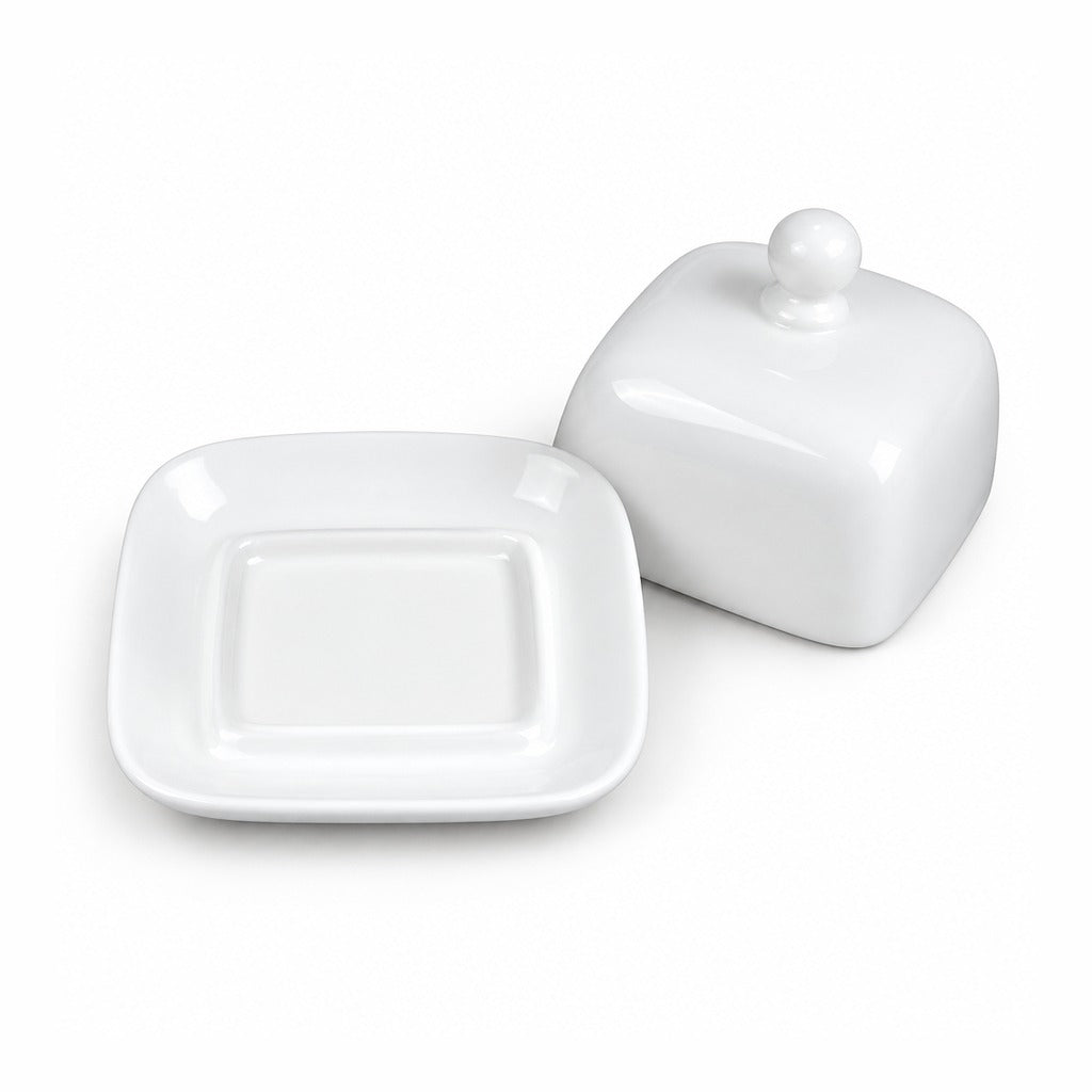 A white ceramic butter dish with a square lid featuring rounded corners and a small spherical knob on top, shown next to its matching square base plate on a clean white background.