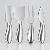 Four stainless steel cheese knives with ergonomic handles, arranged in a row against a light gray background.