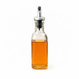 A clear glass bottle with a silver and black pour spout, filled with amber-colored liquid, shown on a plain white background.