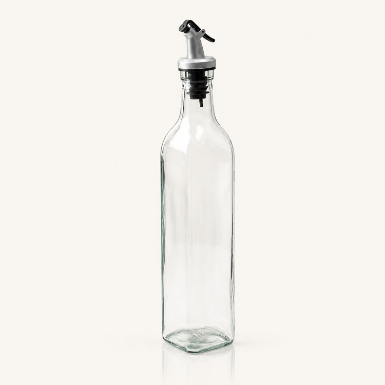 A tall, clear glass bottle with a silver and black metal pour spout, shown on a plain off-white background.