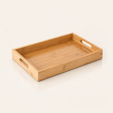 A rectangular bamboo serving tray with integrated cutout handles on two sides, shown on a clean off-white background.
