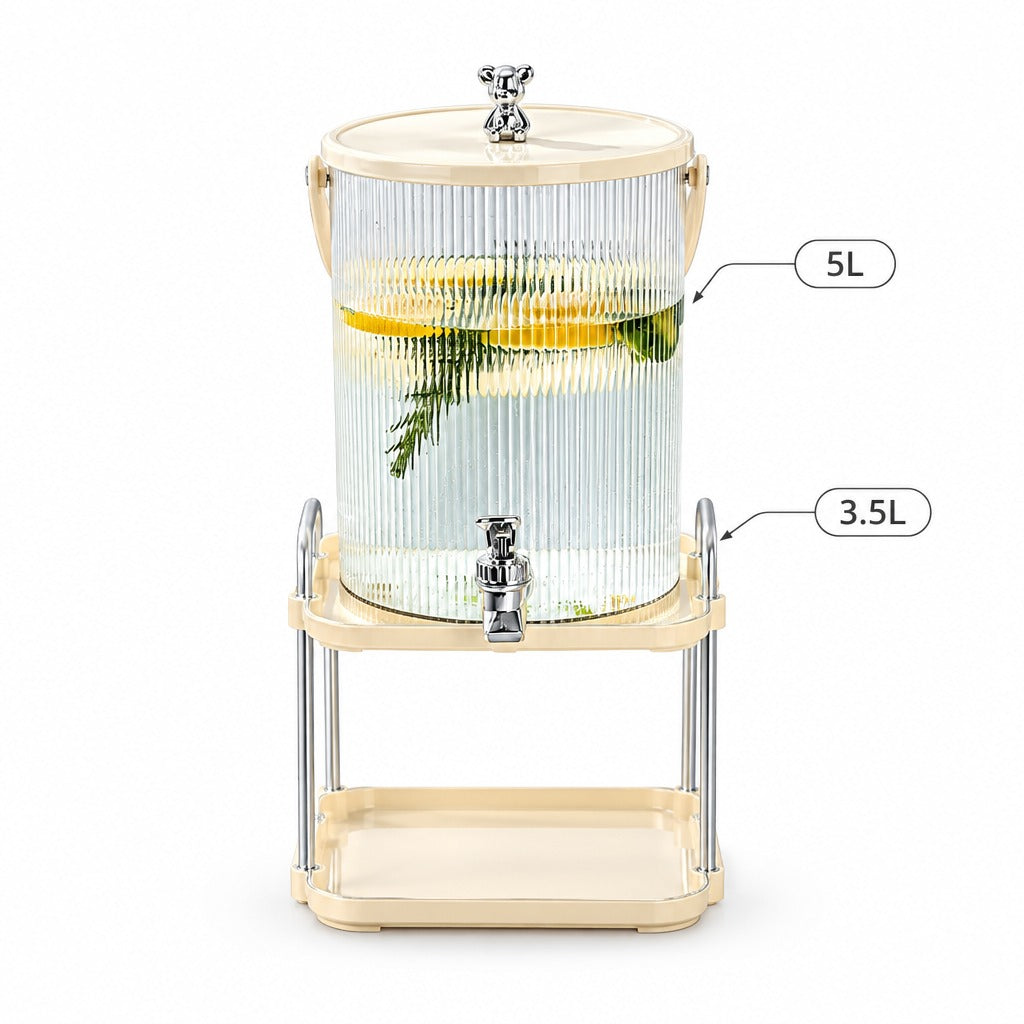 A 5L ribbed clear glass beverage dispenser with a cream-colored plastic lid and base, supported by a matching cream-colored metal stand with a lower tray. The dispenser features a chrome-finished spigot and is shown filled with water, lemon slices, and a green sprig.