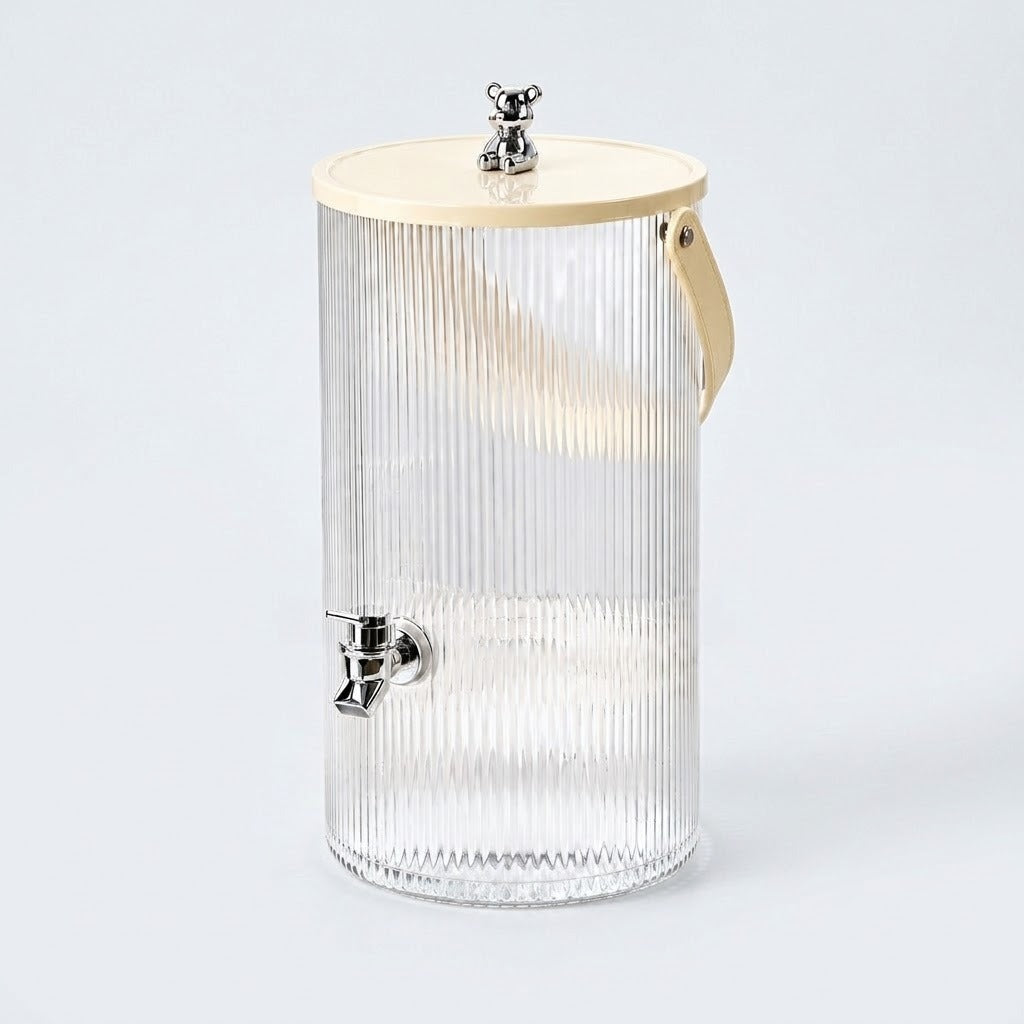 A ribbed clear glass beverage dispenser with a light wood lid, a small metal bear topper, and a side carry handle, shown on a light gray background.