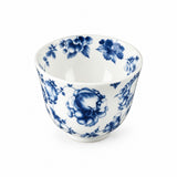 A white ceramic tea bowl decorated with a classic blue floral pattern, photographed against a seamless white background.