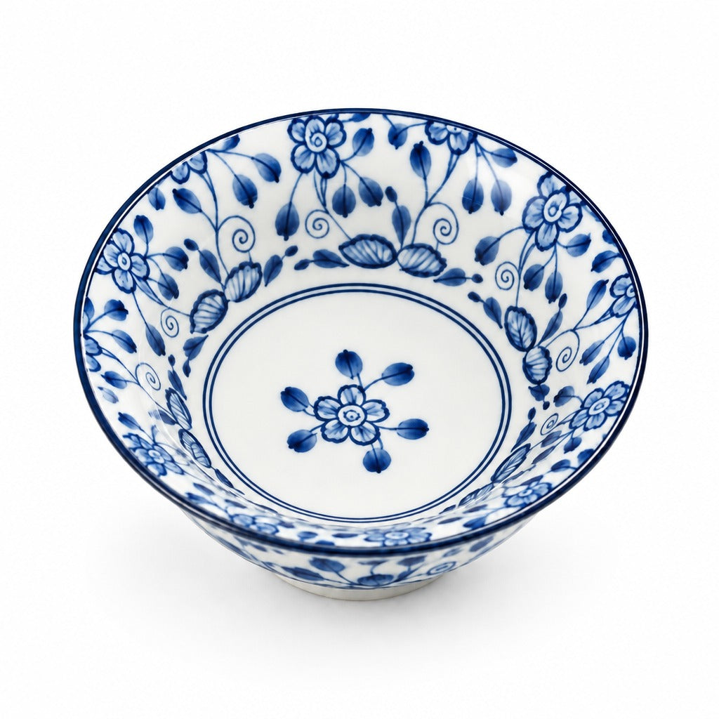 A white ceramic bowl decorated with a blue floral and vine pattern, shown from a top-down angle on a white background.