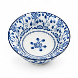 A white ceramic bowl decorated with a blue floral and vine pattern, shown from a top-down angle on a white background.