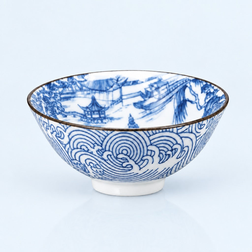 A white ceramic bowl decorated with blue hand-painted traditional Chinese landscape and wave patterns, featuring a thin gold rim, set against a light blue background.