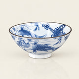 A white ceramic bowl decorated with blue hand-painted fish and floral motifs, featuring a thin dark rim, set against a plain light beige background.