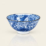 A blue and white porcelain bowl with a detailed floral pattern and a thin black rim, shown on a light beige background with a soft reflection below.