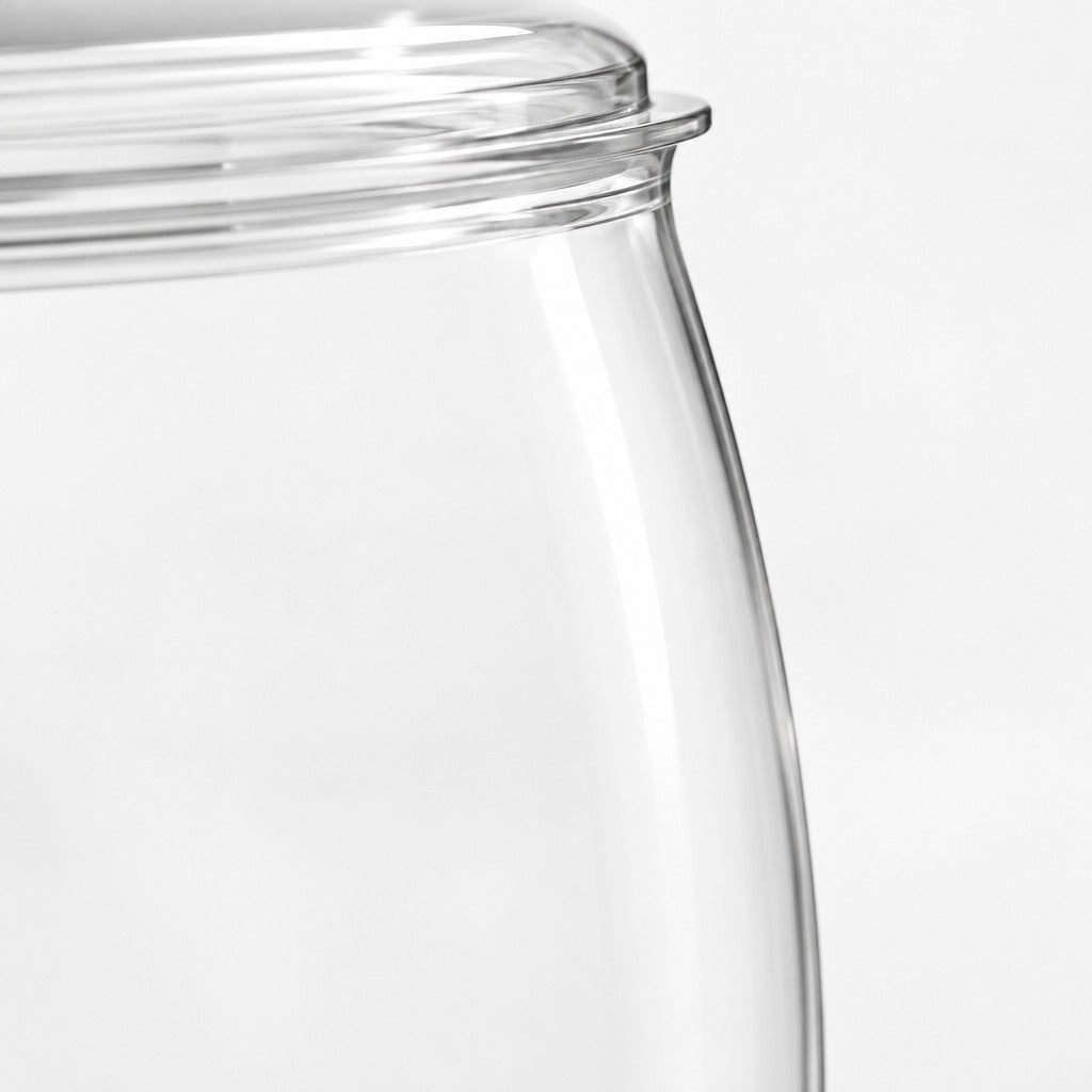 Close-up of a clear glass jar with a flared rim on a light gray background.
