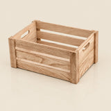 A light natural wood storage crate with handle cutouts on the sides, shown on a clean white background.