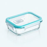 Clear glass food storage container with a translucent aqua blue silicone lid, shown on a clean white background.