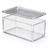 A clear acrylic rectangular storage box with a slotted top lid, shown on a neutral gray background.