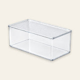 A clear plastic rectangular storage box with a slotted top, shown on a solid light beige background.