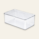A clear plastic rectangular storage box with a ribbed lid, shown on a solid light beige background.