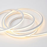 Wall light detail showing coiled white LED strip lighting glowing warm white against a plain white background.